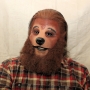 Man wearing latex prosthetic nose and makeup to look like an anthropomorphic brown grizzly bear.