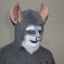 Man wearing foam latex prosthetic nose and makeup to look like an anthropomorphic grey rat.