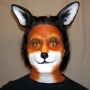 Man wearing latex prosthetic nose and makeup to look like an anthropomorphic fox.