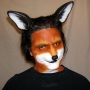 Man wearing latex prosthetic nose and makeup to look like an anthropomorphic fox.