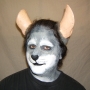 Man wearing foam latex prosthetic nose and makeup to look like an anthropomorphic grey rat.