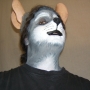 Man wearing foam latex prosthetic nose and makeup to look like an anthropomorphic grey rat.