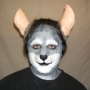 Man wearing foam latex prosthetic nose and makeup to look like an anthropomorphic grey rat.