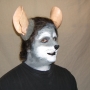 Man wearing foam latex prosthetic nose and makeup to look like an anthropomorphic grey rat.
