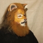 Man wearing foam latex prosthetic nose and makeup to look like an anthropomorphic tan lion.