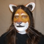 Man wearing foam latex prosthetic nose and makeup to look like an anthropomorphic tan lion.