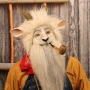 Man wearing foam latex prosthetic nose and makeup to look like an anthropomorphic white goat smoking a pipe. Man wearing foam latex prosthetic nose and makeup to look like an anthropomorphic white goat smoking a pipe.