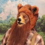 Man wearing latex prosthetic nose and makeup to look like an anthropomorphic brown grizzly bear.