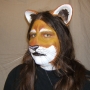 Man wearing foam latex prosthetic nose and makeup to look like an anthropomorphic tan lion.