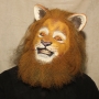 Man wearing foam latex prosthetic nose and makeup to look like an anthropomorphic tan lion.