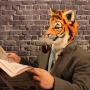 Man wearing foam latex prosthetic face and makeup to look like an anthropomorphic tiger, smoking a pipe and reading a newspaper. Man wearing foam latex prosthetic face and makeup to look like an anthropomorphic tiger, smoking a pipe and reading a newspaper.
