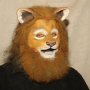 Man wearing foam latex prosthetic nose and makeup to look like an anthropomorphic tan lion.