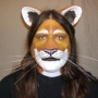 Man wearing foam latex prosthetic nose and makeup to look like an anthropomorphic tan lion.