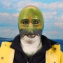 Man wearing foam latex prosthetic face and makeup to look like an anthropomorphic salmon.