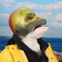 Man wearing foam latex prosthetic face and makeup to look like an anthropomorphic salmon.