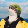 Man wearing foam latex prosthetic face and makeup to look like an anthropomorphic salmon.