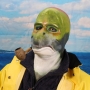 Man wearing foam latex prosthetic face and makeup to look like an anthropomorphic salmon smoking a pipe