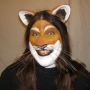 Man wearing foam latex prosthetic nose and makeup to look like an anthropomorphic tan lion.
