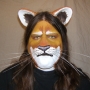 Man wearing foam latex prosthetic nose and makeup to look like an anthropomorphic tan lion.