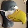 Slush cast latex prosthetic eagle beak placed on a plastic human face cast wiht a strap and painted as an eagle